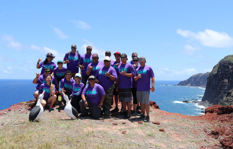 Team Kōkua volunteers gathered alongside two wooden albatross birds in appreciation of Moloka‘i's beautiful northwestern coast. IMG_1217