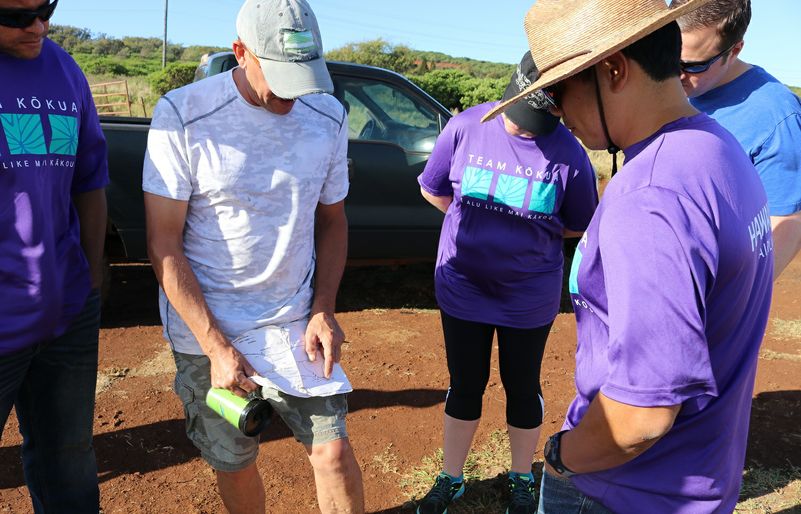 Moloka'i Land Trust Executive Director Butch Haase showing Team Kōkua volunteers the map of the preserve and the route to the restoration site. Molokai Land Trust explaining the route 2