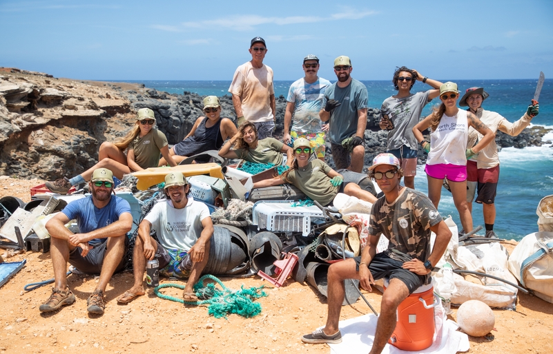 Sustainable Coastlines Hawai‘i volunteers huddling for a group photo after a cleanup event on Moloka‘i, hosted prior to the pandemic. Molokai_SCH_Raftography2019-21