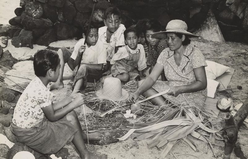 Children watching a weaver strip lau hala in Kona on the Island of Hawaiʻi Lau hala weaving