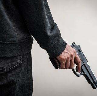 bigstock-A-Man-Holding-A-Gun-In-Hand-T-299137612-4