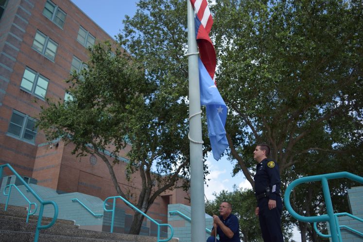 Sr. Officer M. Harrod oversees W. Hand lowering the flags to half mast following the Dallas shooting