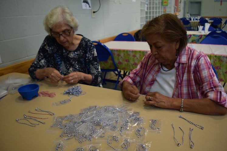 E. Garza and E. Gonzalez making commemorative 911 bracelets at Broadmoor Sr. Ctr.