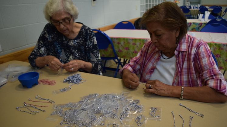 E. Garza and E. Gonzalez making commemorative 911 bracelets at Broadmoor Sr. Ctr.