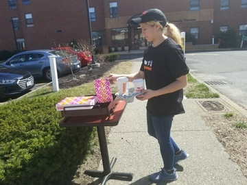 Dunkin' crew member delivering complimentary orders for the elderly