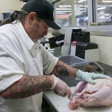 Leo Wheeler, a meat cutter at Whole Foods, prepares a turkey Leo Wheeler, a meat cutter at Whole Foods, prepares a turkey