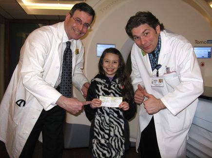 Genevieve Olson Rocha, with, from left, John Holland, M.D., associate professor, and Aaron Martin, radiation therapist