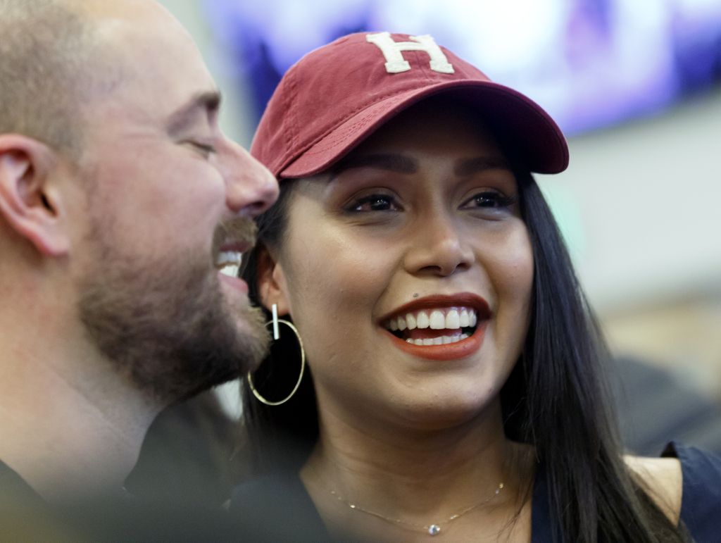 Nattaly Greene (left) celebrates her entry into Harvard. (OHSU/Kristyna Wentz-Graff) woman wearing red baseball hat with a Harvard H on the front