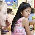 Unhappy Girl Being Gossiped About By School Friends In Classroom
