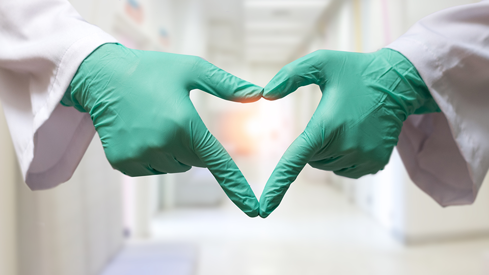 Gloved hands making heart shape