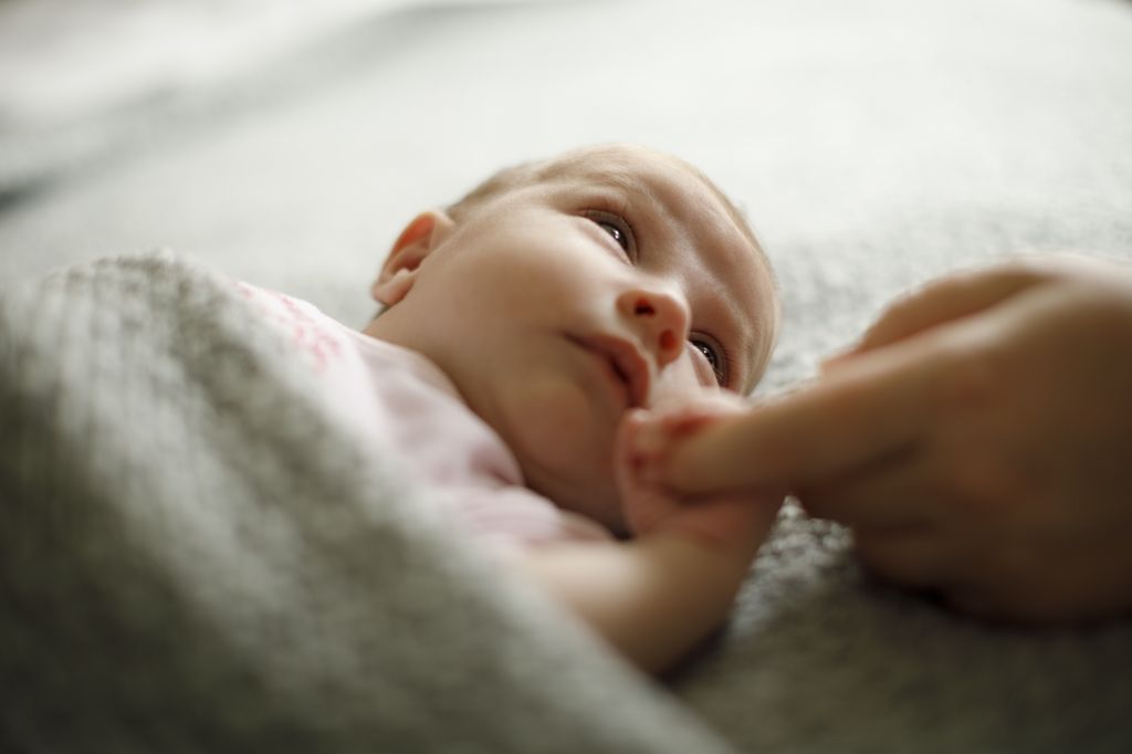 A newborn baby holding mother's hand.