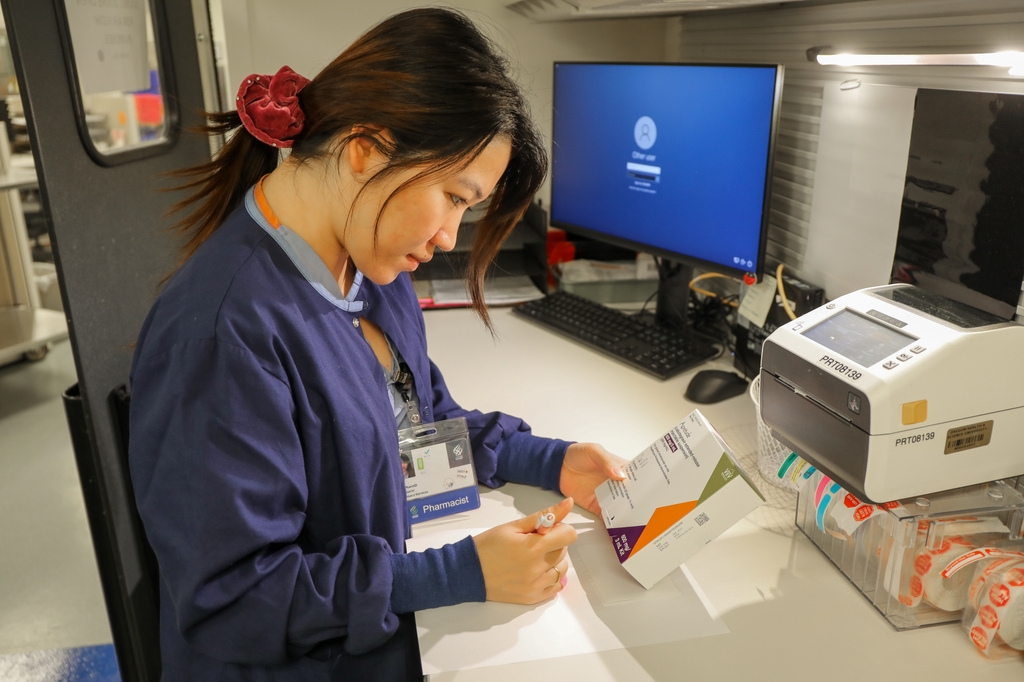 Su Yadana Oo, RPh., farmacéutica en la farmacia de infusión en el hogar de OHSU en Beaverton, verifica el paquete de profilaxis previa a la exposición, o PrPE. La PrPE es un medicamento antirretroviral que reduce en alrededor del 99% el riesgo de contraer VIH por relaciones sexuales. (OHSU/Christine Torres Hicks)