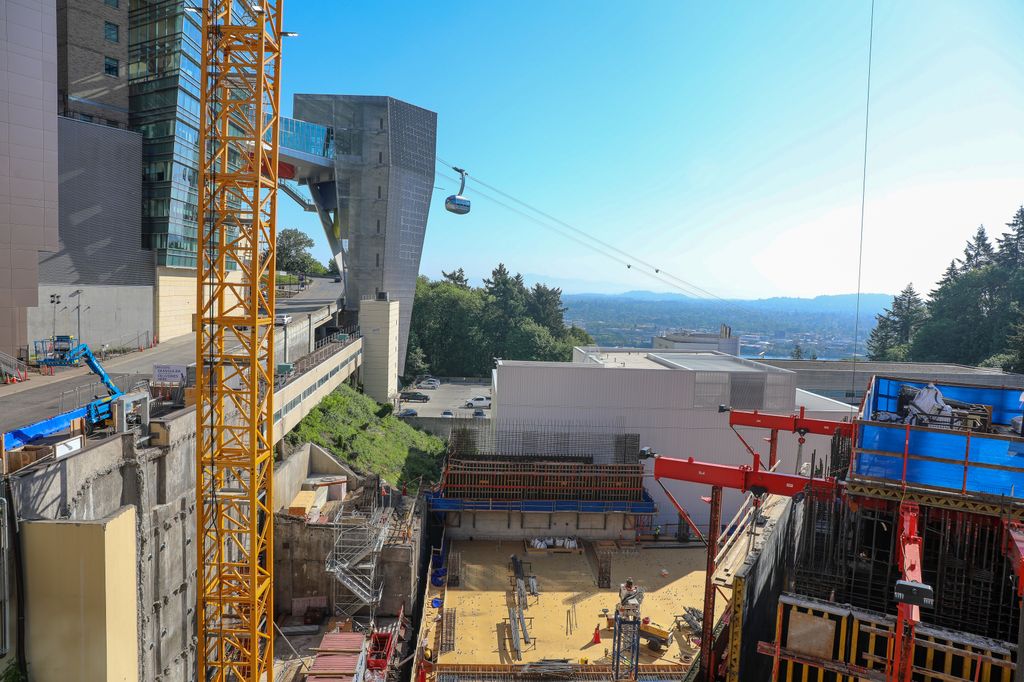 Aerial tram on a sunny day in background, high-rise construction in foreground