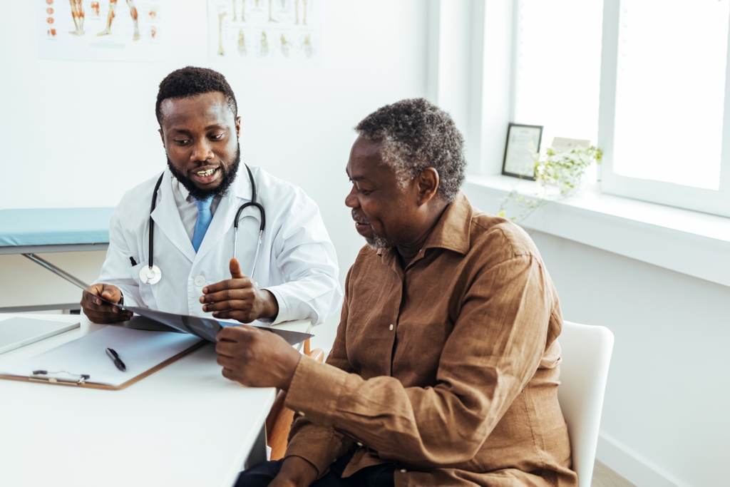Male doctor consults with older male patient