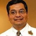Vishnu Mohan, M.D., has short dark hair, eye glasses, and wearing a white coat, smiling.
