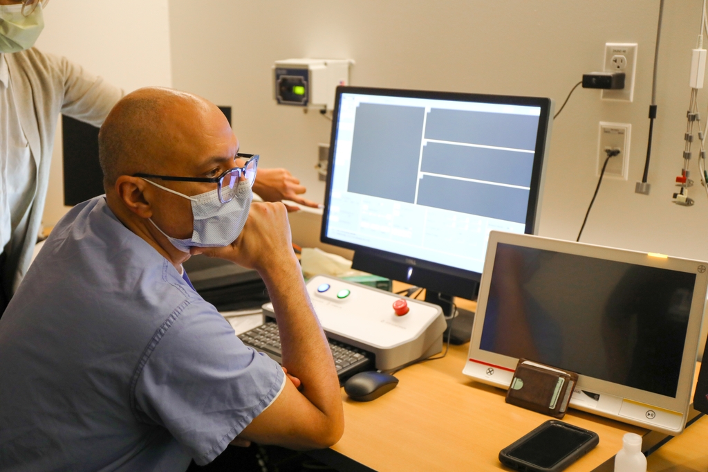 La foto es del Dr. Raslan sentado frente a la pantalla de una computadora mirando datos e imágenes de neurología. Nueva investigación del Dr. Ahmed Raslan y OHSU encuentra que la habilidad de la gente para procesar los números reside en una parte del cerebro que se desarrolló en los primeros estadios de la evolución humana. (OHSU/Christine Torres Hicks)