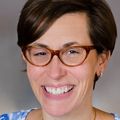 Laurel Hallock-Koppelman, D.N.P., F.N.P.-C., A.P.R.N. (OHSU) has short brown hair and red glasses, smiling against a gray background.