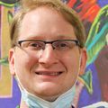 Andrew Gray, asistente de enfermería certificado en oncología de OHSU, que también tiene cáncer, trabaja con pacientes con cáncer y se ofrece como voluntario constantemente en su tiempo libre para continuar compartiendo su positividad y aliento con los demás. Tiene el pelo corto, rubio claro/rojo, gafas y se encuentra en la clínica CHH2 de OHSU.