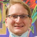 Andrew Gray, an oncology certified nursing assistant at OHSU, who has cancer himself, works with cancer patients and volunteers consistently in his free time to continue to share his positivity and encouragement with others. He has short light blond/red hair, eye glasses and stands at the CHH2 clinic at OHSU.