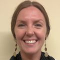 Callie Krewson, D.O., has long reddish blonde hair, pulled back, smiling against a beige background.