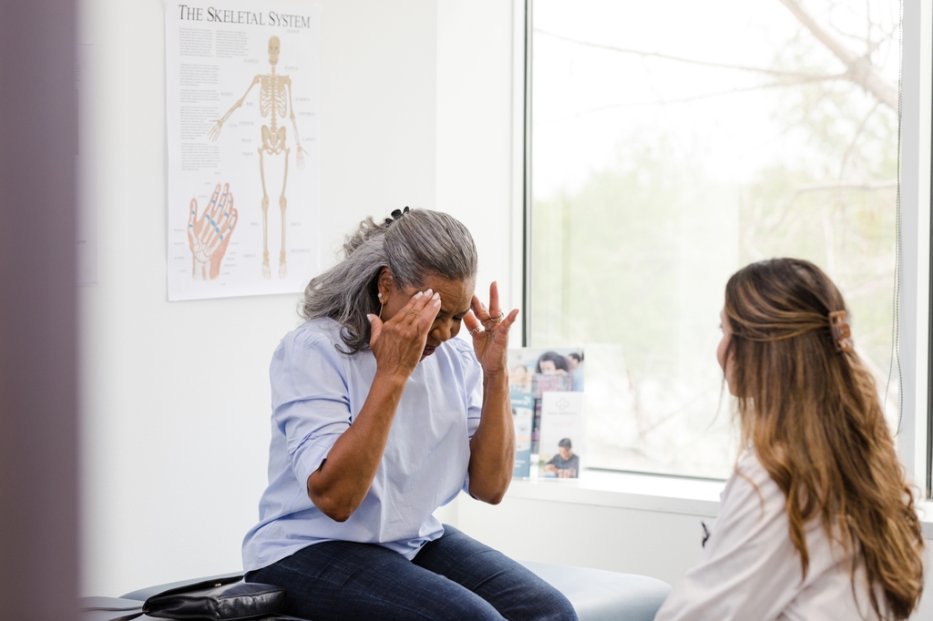Una mujere es no bien en la oficina de la doctor. 