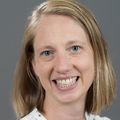 Melissa Novak, D.O., has long blonde hair and a white shirt, smiling.