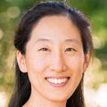 Vanderlene Kung, M.D., Ph.D., tiene el pelo largo y negro recogido hacia atrás y sonríe.