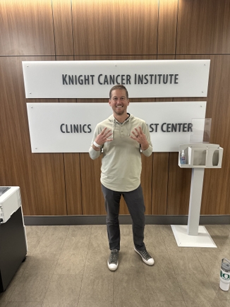 Matt Hazard, paciente de OHSU, levanta ocho dedos antes de iniciar su octava y última sesión de quimioterapia. (Cortesia)