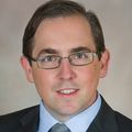 Kenneth Gundle has short black hair, eye glasses and a suit and tie.