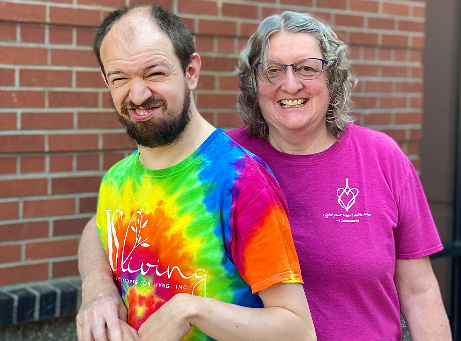 Photo is of Eric Stewart, in a tie-dye shirt, and his mom, Susan, wearing a pink shirt, smiling. Eric Stewart has a rare disease known as CTX. His mother, Susan Stewart, brought him to OHSU for his diagnosis and she continues to advocate for CTX screening and treatment. Researchers at OHSU discovered biomarkers essential to identifying and treating the disease, which led to a clinical trial at OHSU that in February culminated in FDA approval of an effective treatment for patients. (OHSU/Christine Torres Hicks)