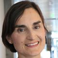 Laura Heiser, Ph.D., has short dark hair, black top, and is smiling at Knight Cancer Institute.