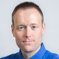 Jeffrey W. Tyner, Ph.D., has short light hair, a blue shirt and tie, smiling against a light gray background.