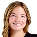Raegan Scheid, diseñadora y paciente de Nike-OHSU Doernbecher Freestyle, tiene cabello castaño/rubio largo y una camiseta negra.