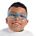 El diseñador Sergio Cano Márquez, paciente de Nike-OHSU Doernbecher Freestyle, tiene cabello corto oscuro y ondulado, gafas y una camiseta blanca.