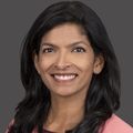Tanaya Shree, M.D., Ph.D., has long, wavy black hair and a coral pink top.