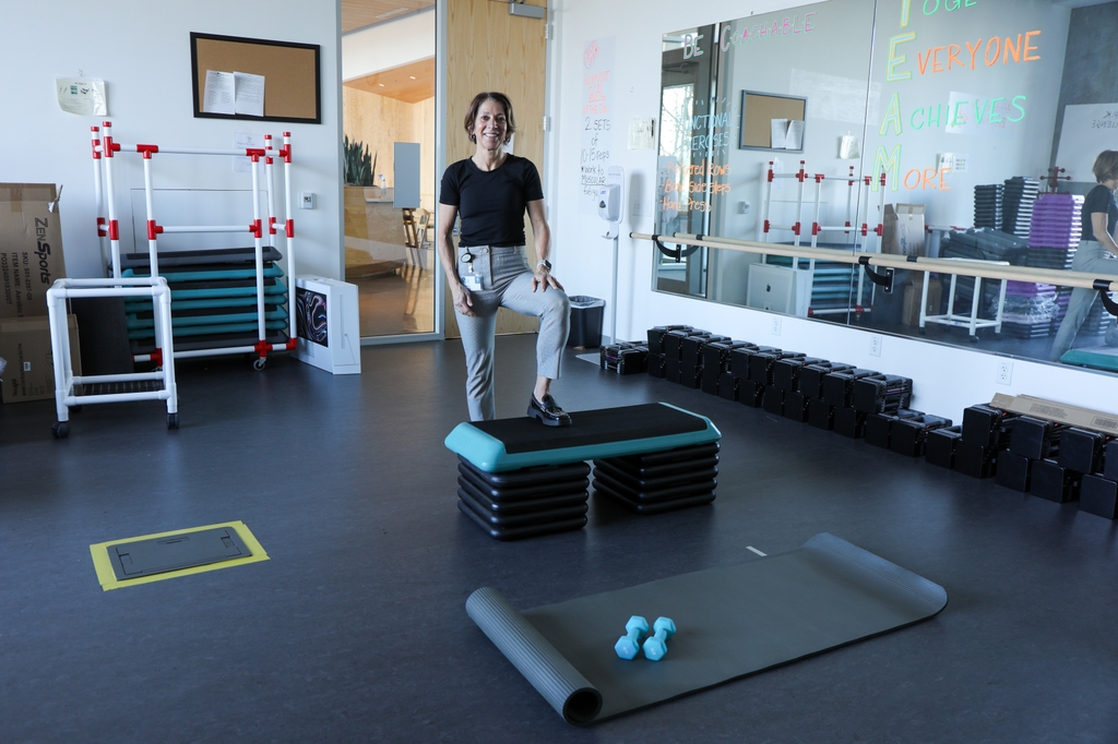 Kerri stands on an exercise platform in an exercise room.