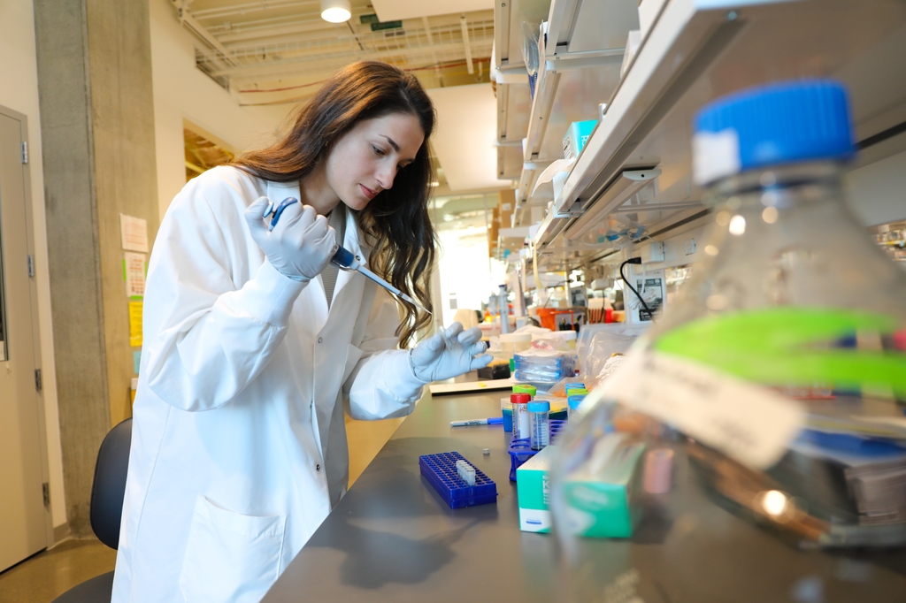 Ariana Sattler, Ph.D., is first author on a new study that found that certain nerves may support pancreatic cancer growth. (OHSU/Christine Torres Hicks) Ariana pipettes liquid into tubes in the Ece Eksi lab at the Knight Cancer Institute.