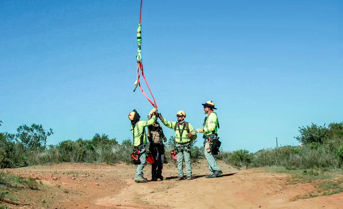 Two pairs of linemen are dropped off near a series of poles. They make a short hike to the pole they will work on for the next few hours. 