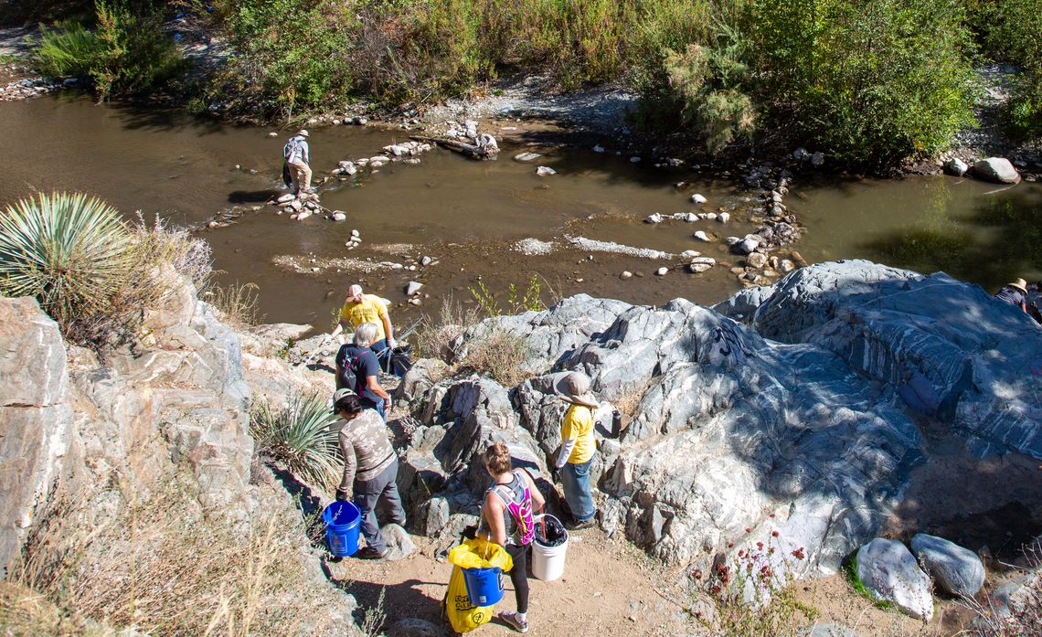 Volunteers searching for trash and inspecting human-made dams in the San Gabriel River.
