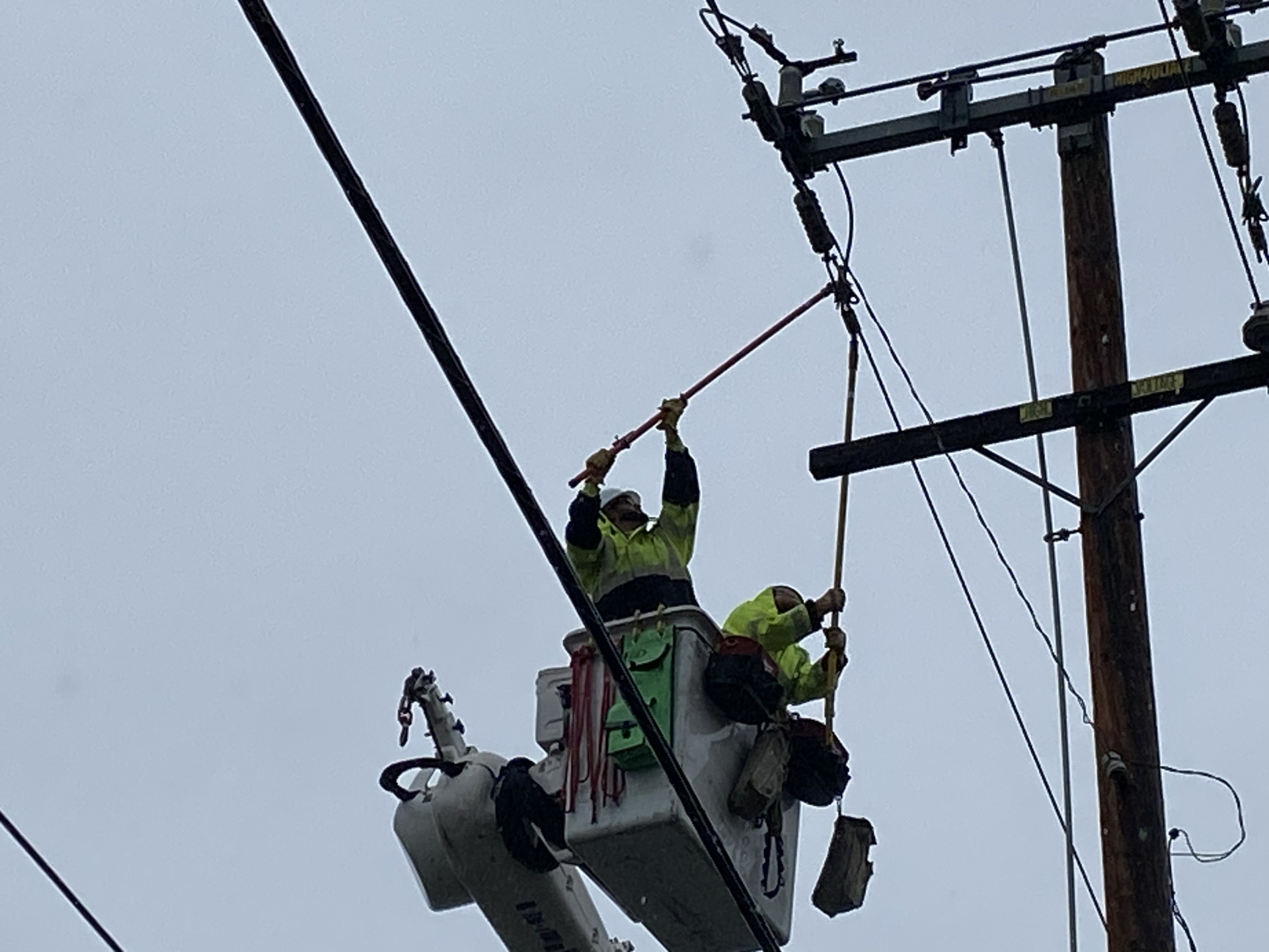 SCE journeyman linemen Tim Patterson (L) and Ryan Davidson use hot sticks to replace damaged connectors. 