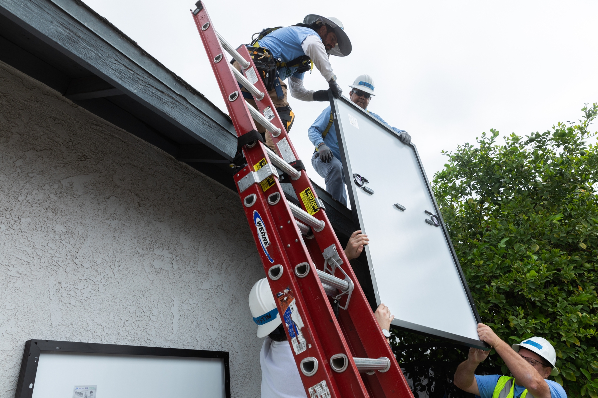 A photo of rooftop solar panels being installed on a house.
