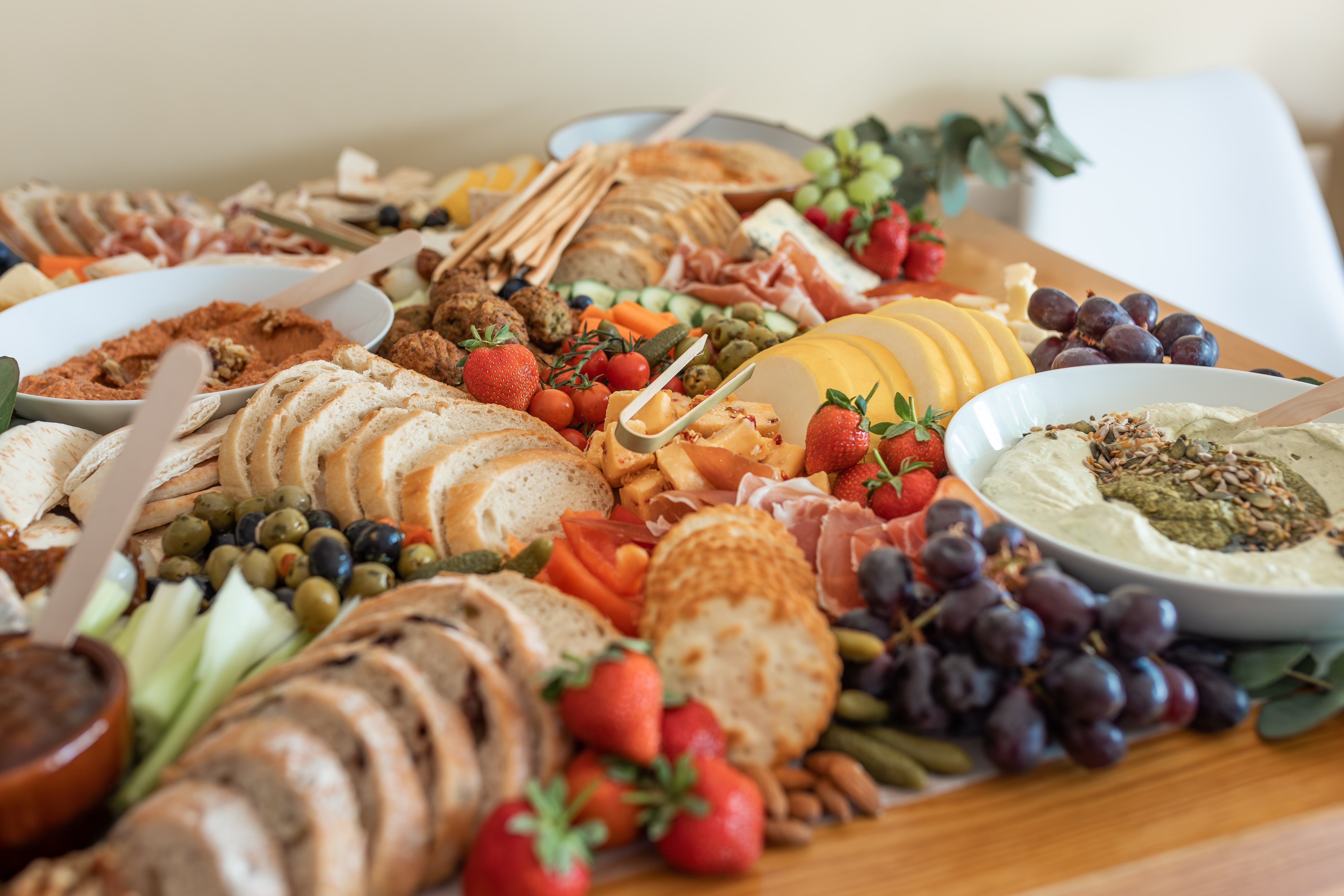 Charcuterie board with meat, cheese, fruit, nuts and spread.