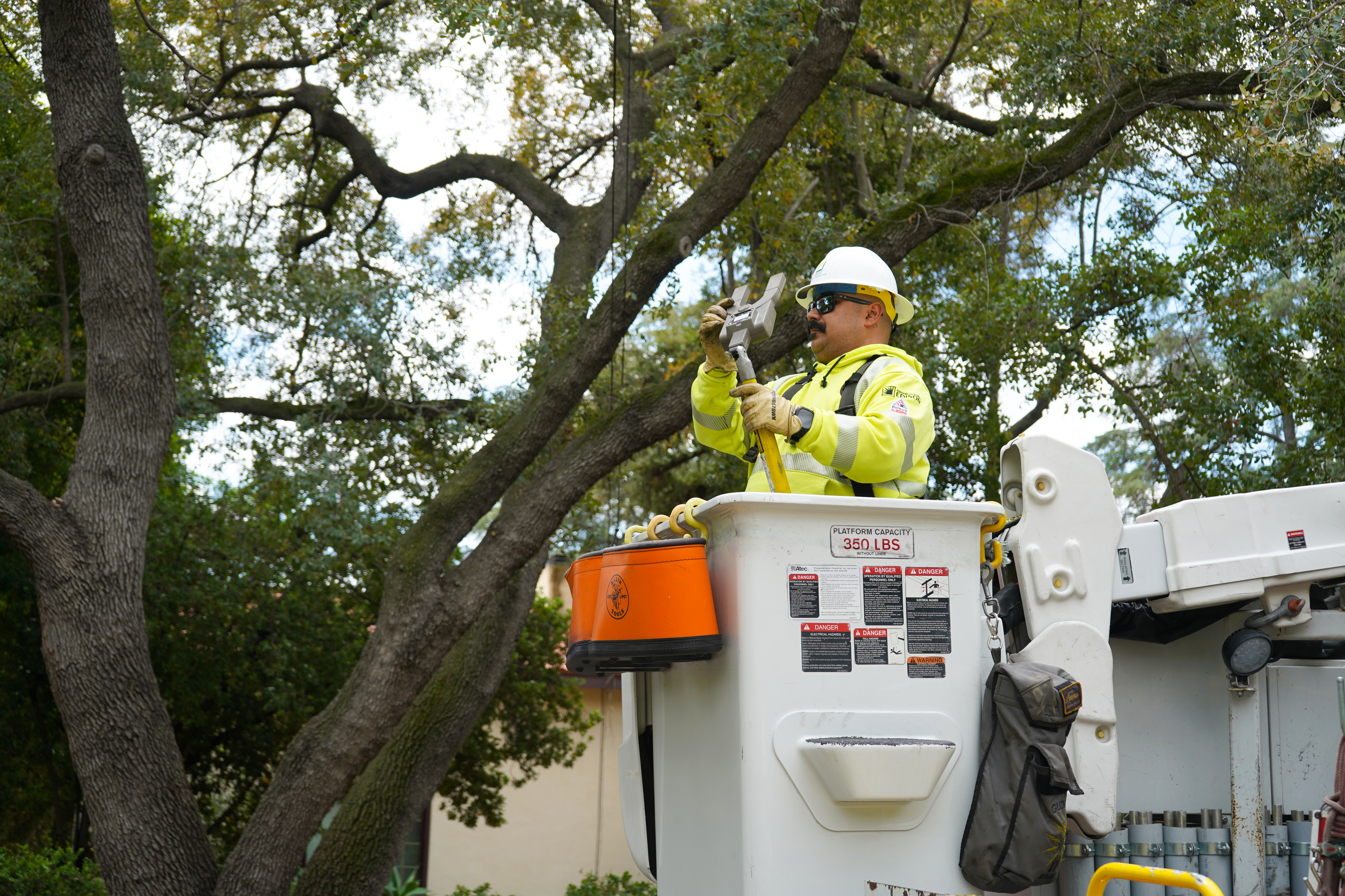 Omar Guzman, SCE troubleman, using a high-voltage amp to check the amperage readings of a power line in Pasadena. 