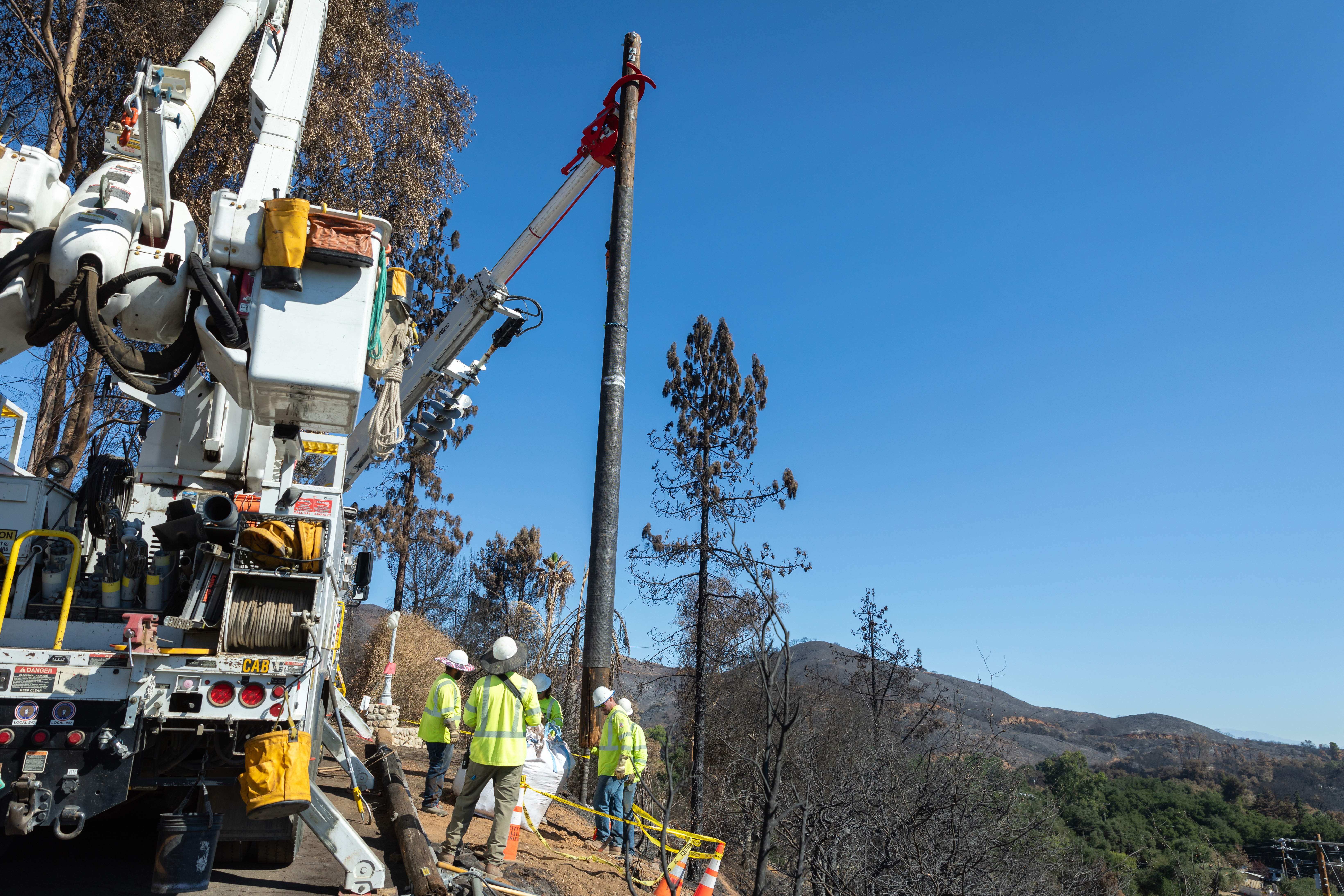 Lineworkers used cranes to set the new poles, secured the surrounding area with rocks and dirt, then strung the new wires before reenergizing the community. 