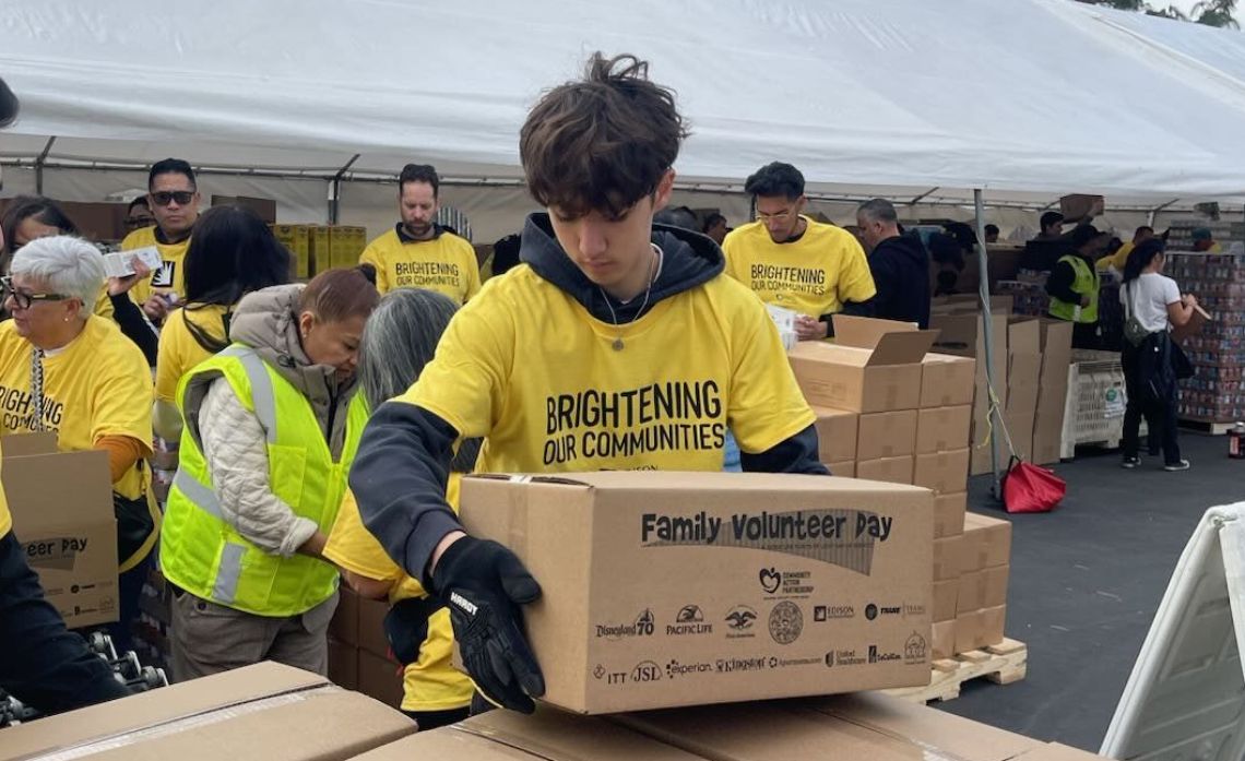 Focused on service, Noah Loyola Renfeldt joins hundreds of volunteers to pack nutritious meals for the holidays.