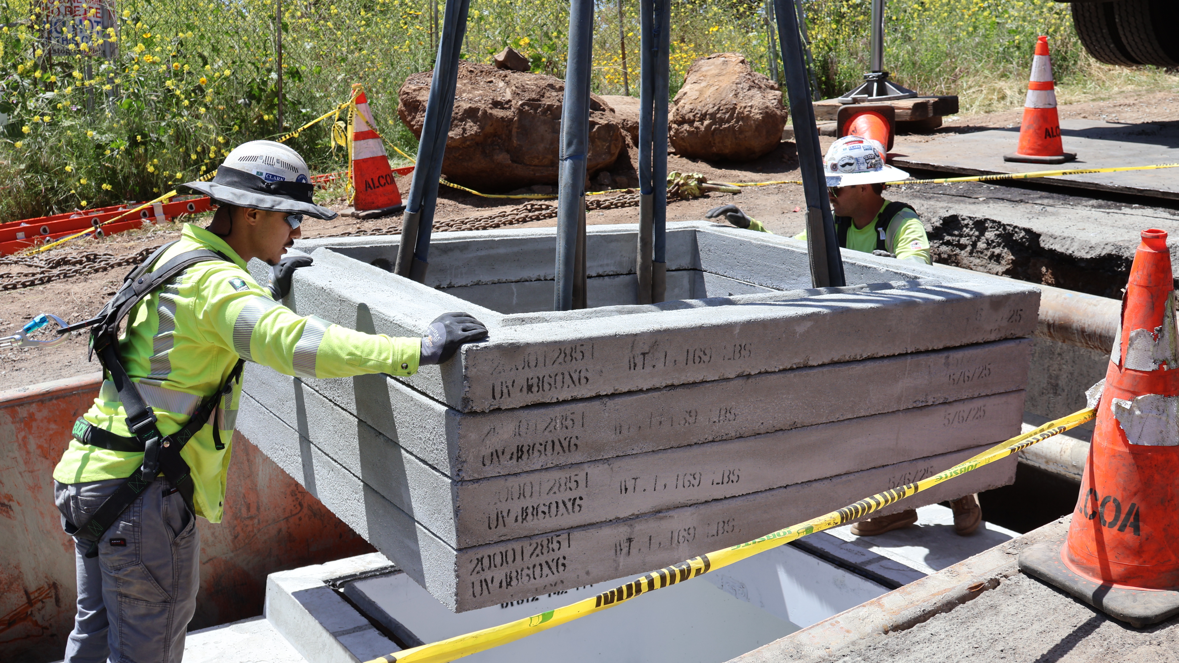 Underground vaults are installed in two pieces, lowered into place by crane.