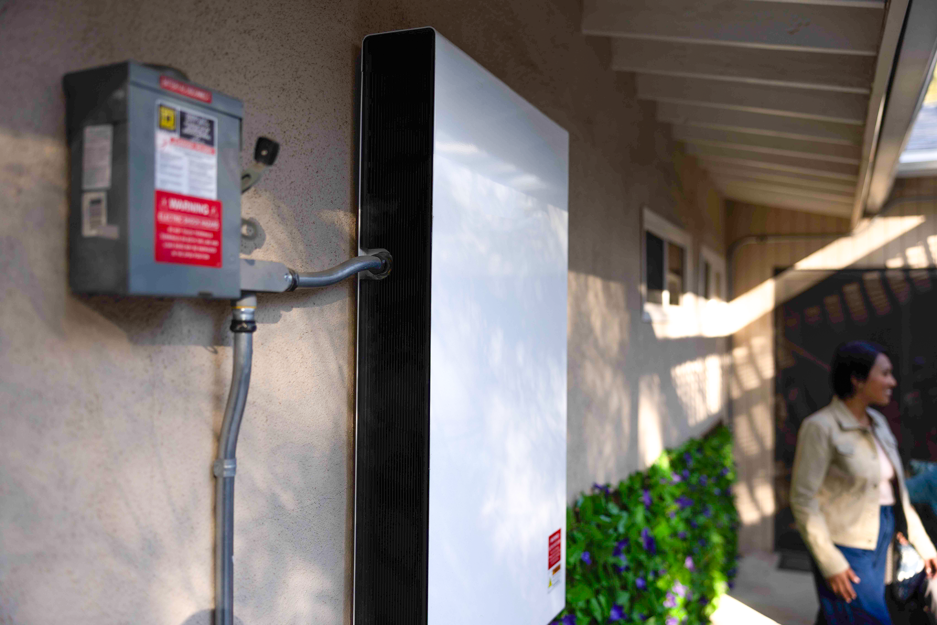 During an outage, a battery’s power control system releases stored solar energy into the home’s circuit to provide energy.