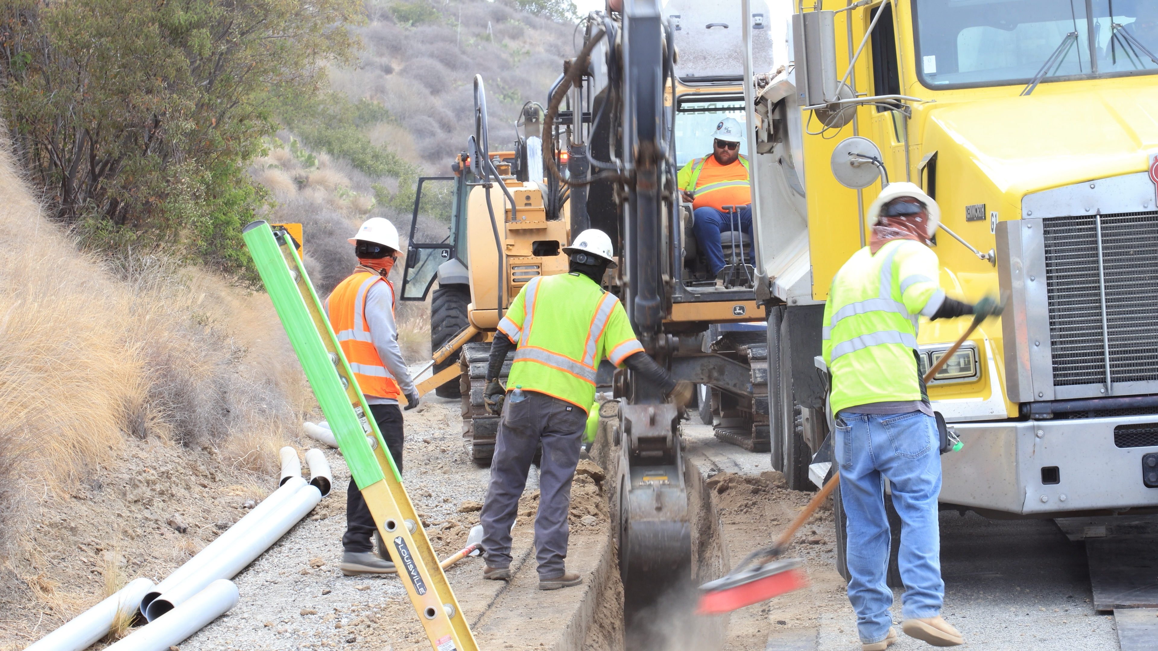 Cews dig out the trench path that will house underground wire and conduit.