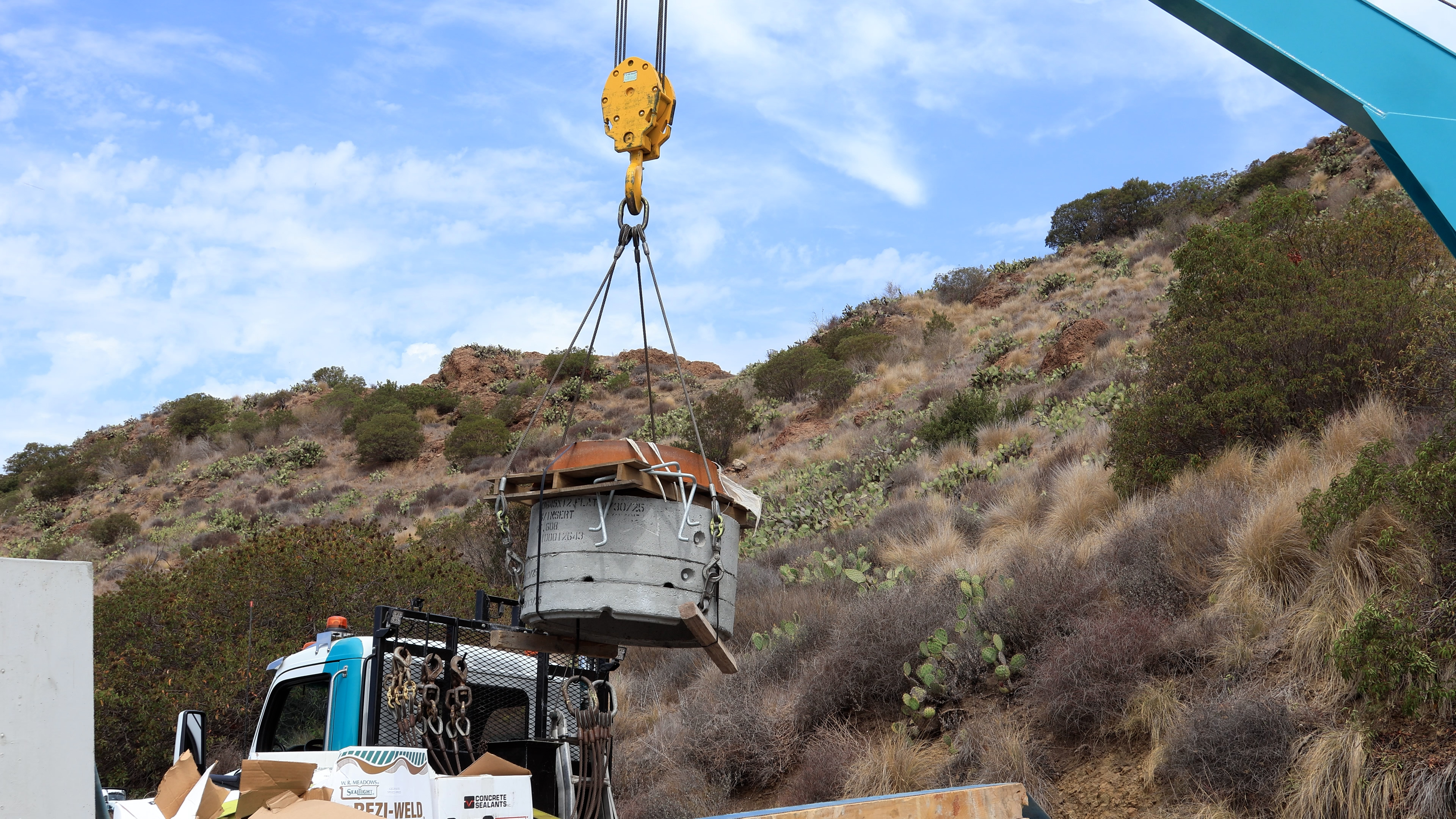 A crane lifts part of a manhole — an underground structure that will act as a maintenence point for crews to work on the system.