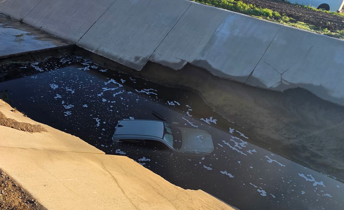 The roof of a vehicle remains visible in a remote water canal where an SCE line crew spotted the wreck.